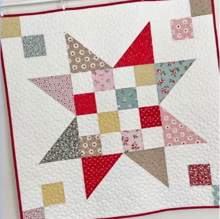 Baby quilt with charm squares and layer cake